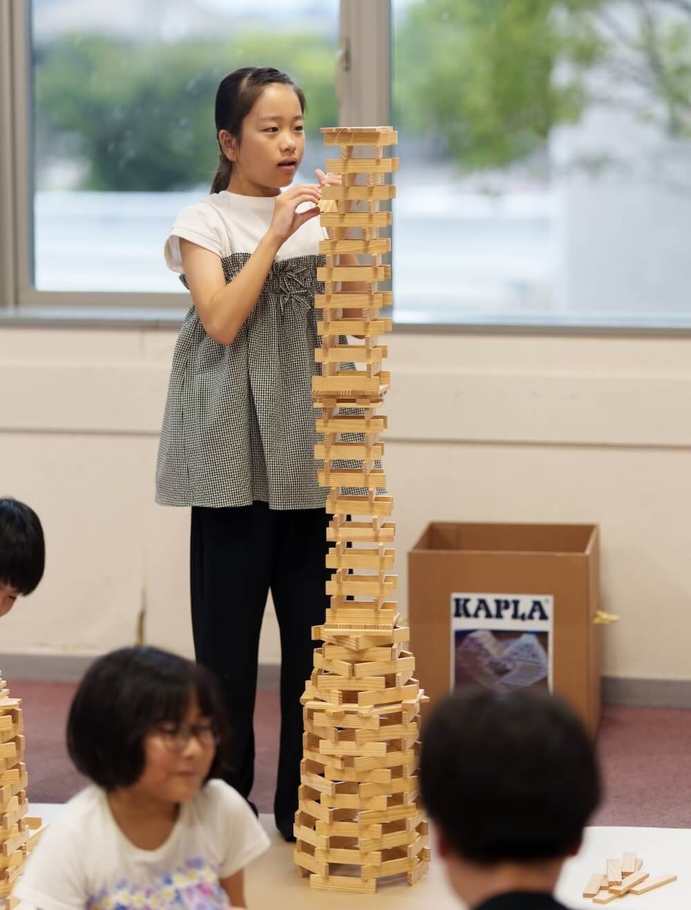 キッズコーナーでカプラのタワーづくりに挑戦する子ども