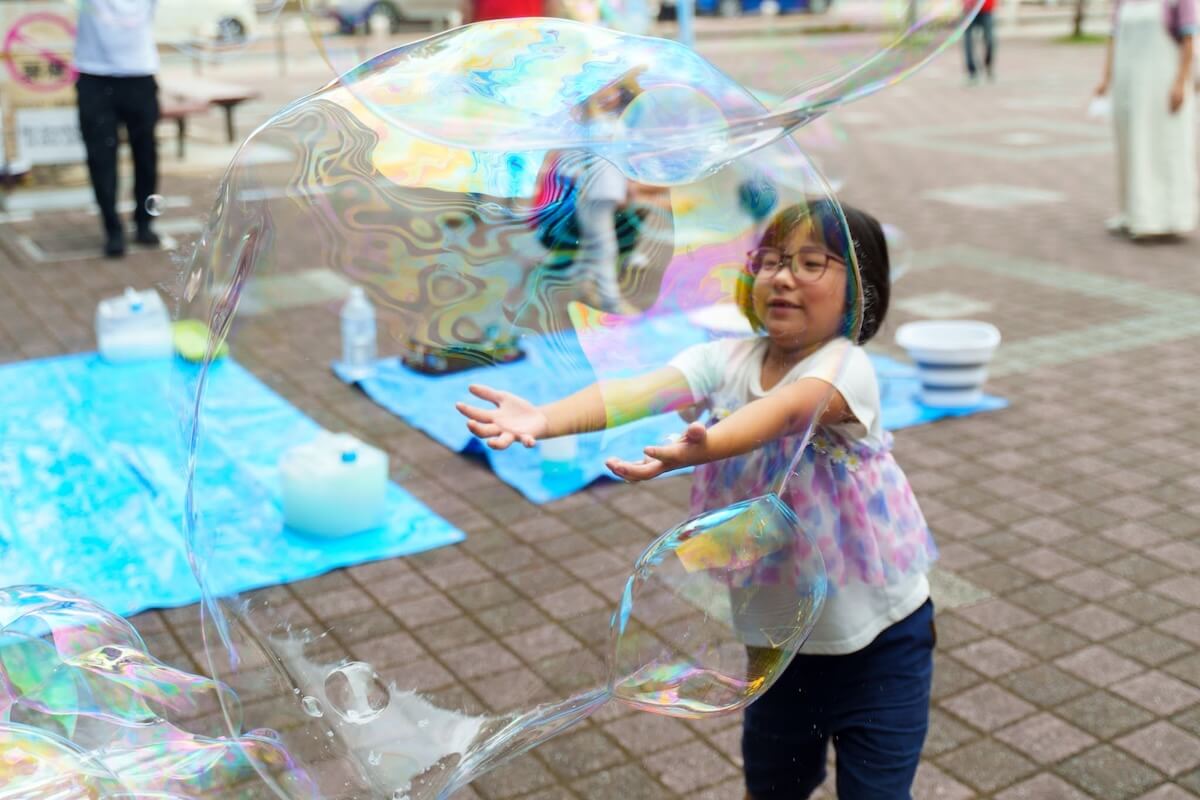 巨大シャボン玉に包まれて笑顔の女の子